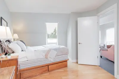 a white bedroom with a bed and a window at Marquise by Outpost Whistler in Whistler