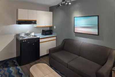 a living room with a couch and a kitchen at Accent Inns Victoria in Victoria