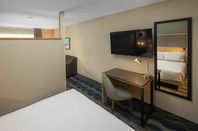 a hotel room with a bed and a desk with a television at Accent Inns Victoria in Victoria