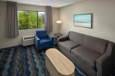 a living room with a couch and a blue chair at Accent Inns Victoria in Victoria