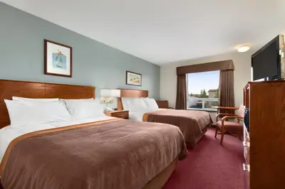 a hotel room with two beds and a window at Super 8 by Wyndham Yellowknife in Yellowknife
