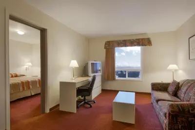 a hotel room with a desk and a bed at Super 8 by Wyndham Yellowknife in Yellowknife
