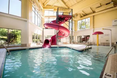 a pool with a water slide in a building at Comfort Inn & Suites in Langley