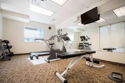 a gym with tread machines and a flat screen tv at Comfort Inn & Suites in Langley