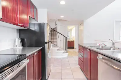 a kitchen with red cabinets and a stainless steel refrigerator at Tyndall Stone by Outpost Whistler in Whistler