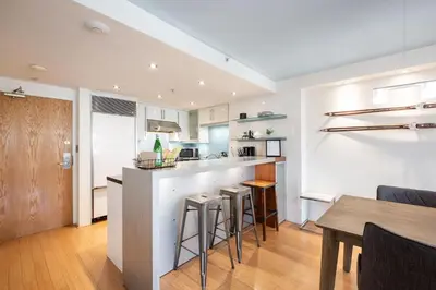 a kitchen and dining room with a counter and stools at Woodrun by Outpost Whistler in Whistler