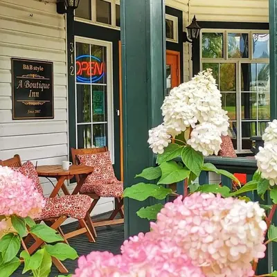 a porch with chairs and a table and flowers at Courthouse Inn Revelstoke in Revelstoke