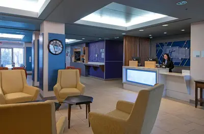 a woman standing in a lobby with a waiting room at Holiday Inn Express Kamloops by IHG in Kamloops