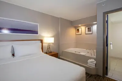 a hotel room with a bed and a bath tub at Holiday Inn Express Kamloops by IHG in Kamloops