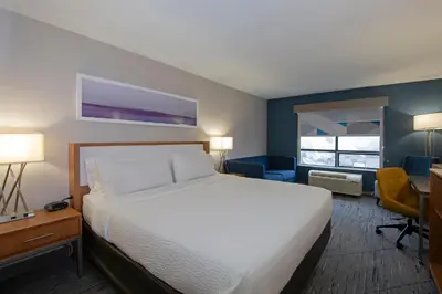 a hotel room with a bed and a desk and chair at Holiday Inn Express Kamloops by IHG in Kamloops