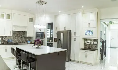 a kitchen with white cabinets and a large island at Kim's Place in Surrey