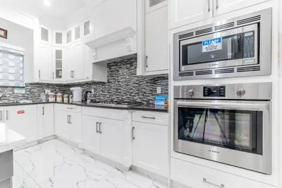 a white kitchen with white cabinets and appliances at Kim's Place in Surrey