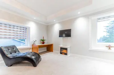 a living room with a leather chair and a fireplace at Kim's Place in Surrey