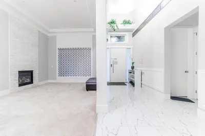 a living room with white walls and a fireplace at Kim's Place in Surrey