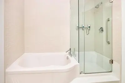 a bathroom with a shower and a tub and a sink at Four Points by Sheraton Edmonton Gateway in Edmonton