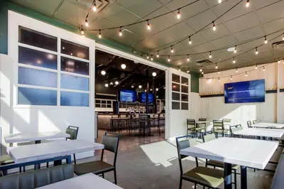 a dining room with tables and chairs and a bar at Four Points by Sheraton Edmonton Gateway in Edmonton