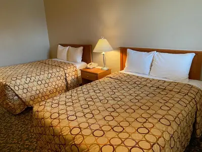a hotel room with two beds and a telephone at Aspen Motor Inn in Drayton Valley