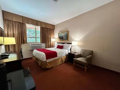 a hotel room with a bed and a chair at SureStay by Best Western Richmond Vancouver Airport in Richmond