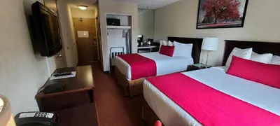 a hotel room with two beds and a television at SureStay by Best Western Richmond Vancouver Airport in Richmond