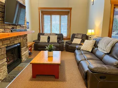 a living room with leather couches and a fireplace at Pinnacle Ridge Condos by Fernie Central Reservations in Fernie