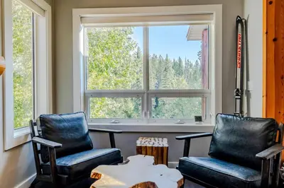 two chairs and a table in front of a window at Ski In & 15 Minute Walk to the Lifts Hot Tub AC Pet Friendly in Fernie