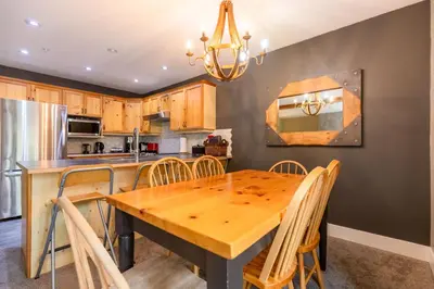 a kitchen with a wooden table and chairs at Ski In & 15 Minute Walk to the Lifts Hot Tub AC Pet Friendly in Fernie