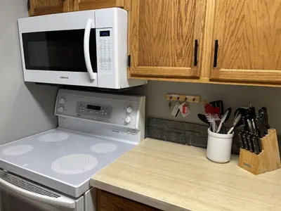 a kitchen with a microwave oven and a stove at Griz Inn by Fernie Central Reservations - Right on The Slopes in Fernie