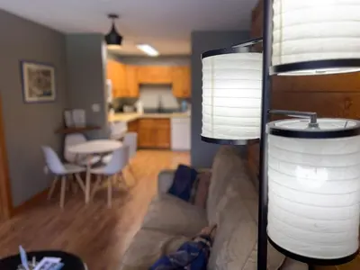 a living room with a couch and a table and a kitchen at Griz Inn by Fernie Central Reservations - Right on The Slopes in Fernie