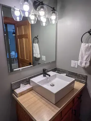 a bathroom with a white sink and a mirror at Griz Inn by Fernie Central Reservations - Right on The Slopes in Fernie