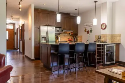 a kitchen with a bar with blue bar stools at Luxurious 901 Condos by Fernie Central Reservations in Fernie
