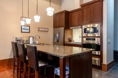 a kitchen with a large island with bar stools at Luxurious 901 Condos by Fernie Central Reservations in Fernie