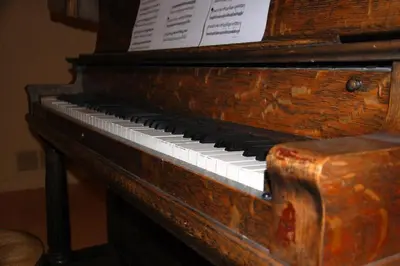 an old piano with a paper sitting on top of it at A Vacation Paradise at Quail Ridge B&B in Kelowna