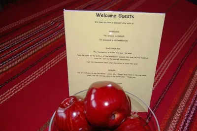 a plate of red cherries on a table with a menu at A Vacation Paradise at Quail Ridge B&B in Kelowna