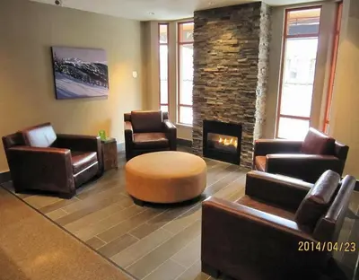 a living room with leather furniture and a fireplace at Studio suite located in the heart of Whistler village in Whistler