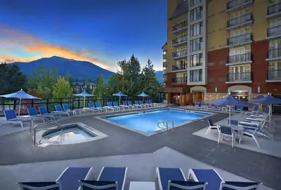 a swimming pool with chairs and a hotel at Hilton Whistler Resort & Spa in Whistler
