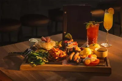 a plate of food on a table with a drink at Hilton Whistler Resort & Spa in Whistler