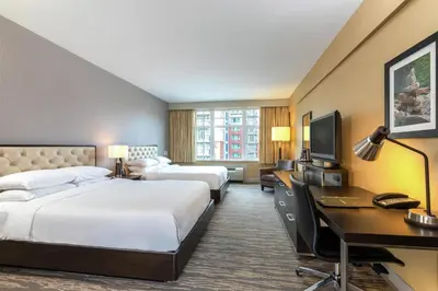 a hotel room with two beds and a desk at Hilton Whistler Resort & Spa in Whistler
