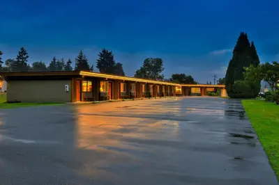 a building with a parking lot in front of it at Arbutus Grove Motel in Parksville