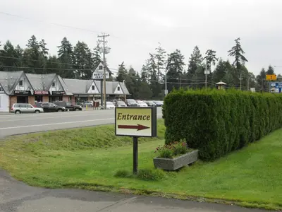 a sign on the side of a road next to a street at Arbutus Grove Motel in Parksville