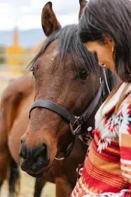 a woman standing next to a brown horse at Myra Canyon Guest Ranch in Kelowna