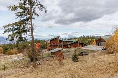 a large wooden house in the middle of a field at Myra Canyon Guest Ranch in Kelowna
