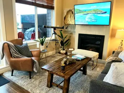 a living room with a television above a fireplace at Port Renfrew Vacation Rentals in Port Renfrew