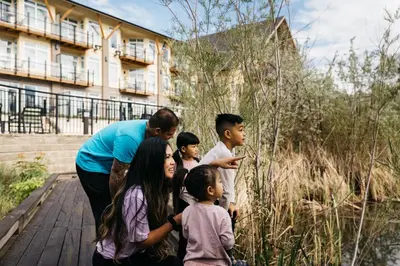 a woman and a group of children standing on a boardwalk at Summerland Waterfront Resort & Spa in Summerland