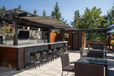 an outdoor bar with chairs and tables on a patio at Four Points by Sheraton Victoria Gateway in Victoria
