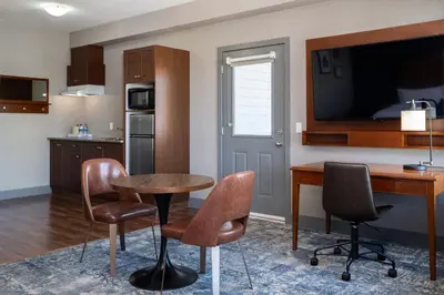 a kitchen and dining room with a table and chairs at Four Points by Sheraton Victoria Gateway in Victoria