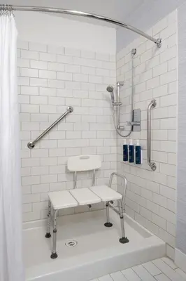 a shower with a bench in a bathroom at Four Points by Sheraton Victoria Gateway in Victoria