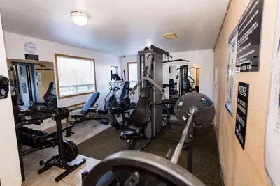 a gym with several treadmills and machines in a room at Super 8 by Wyndham Drayton Valley in Drayton Valley