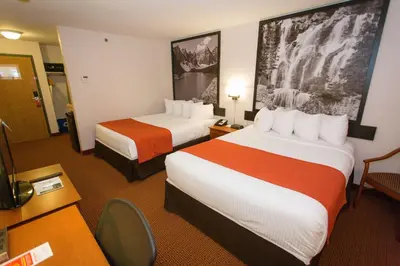 a hotel room with two beds and a desk at Super 8 by Wyndham Drayton Valley in Drayton Valley