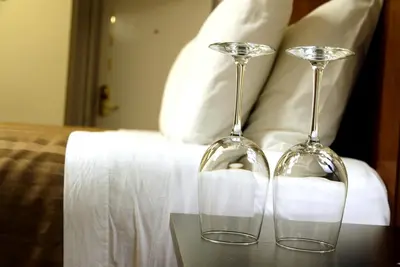 two wine glasses sitting on a table next to a bed at Hotel Squamish in Squamish