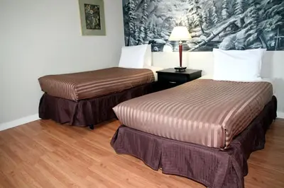 a hotel room with two beds and a lamp at Hotel Squamish in Squamish